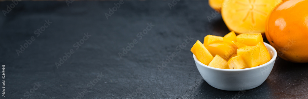 Kaki fruits on a slate slab (selective focus) Kaki fruits on a slate slab (selective focus)