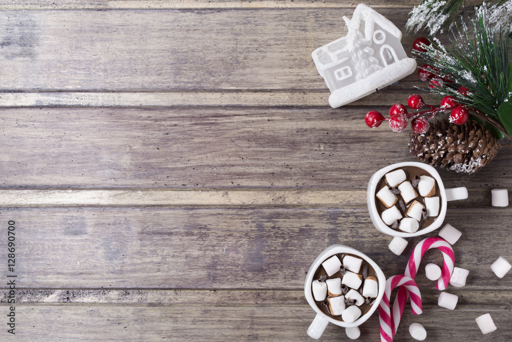 Christmas still life - two cups of hot chocolate with marshmallow, candies, toy house and branch of fir with berries. Copy space Christmas still life - two cups of hot chocolate with marshmallow, candies, toy house and branch of fir with berries. Copy space