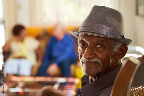 Senior Black Man With Hat Looking At Camera In Hospice