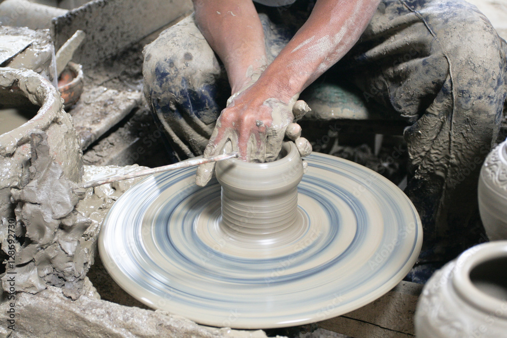 Male hand sculpting pot in pottery Male hand sculpting pot in pottery