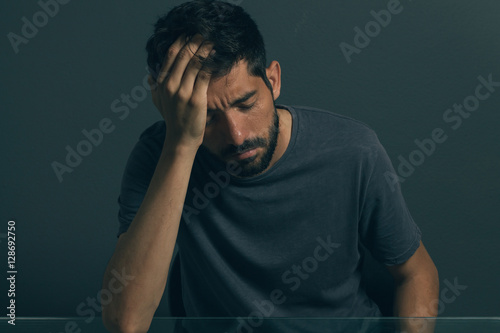 Sad man sitting in dark room. Depression and anxiety disorder concept