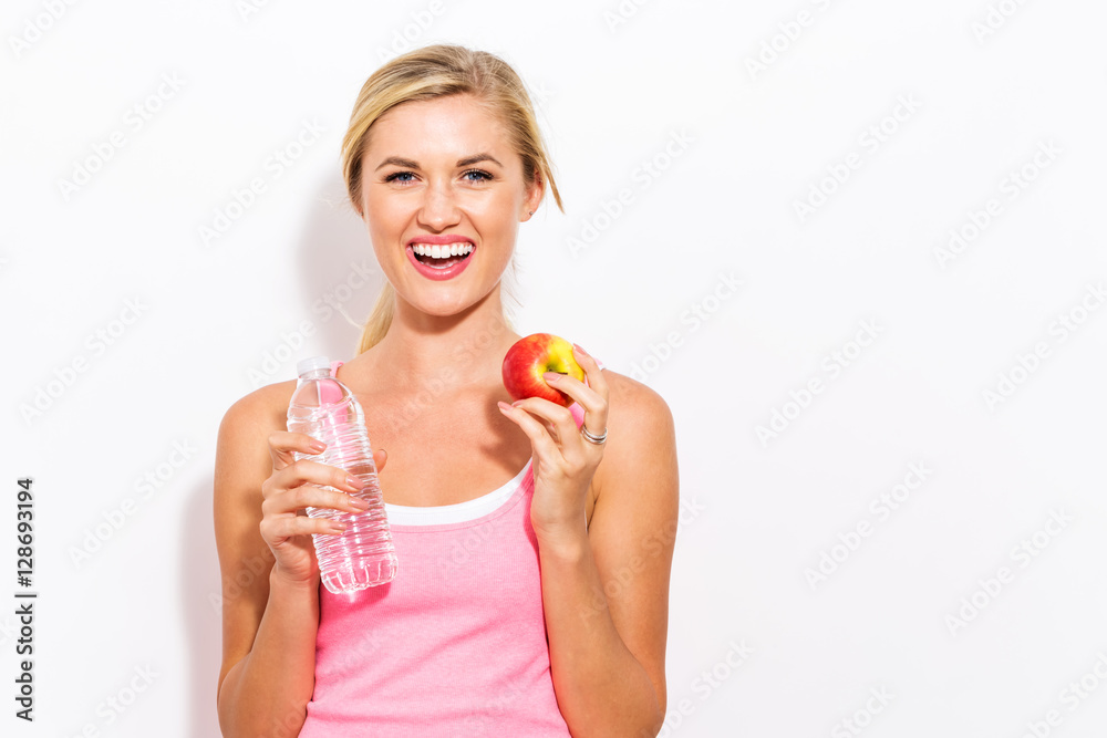 Happy young woman holding apple and water Happy young woman holding apple and water