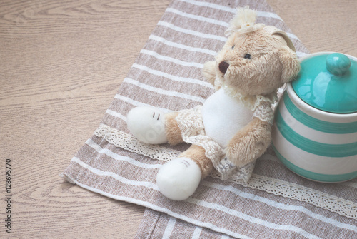 Matte style of green pastel porcelain jar and little bear doll with cute fabric. photo