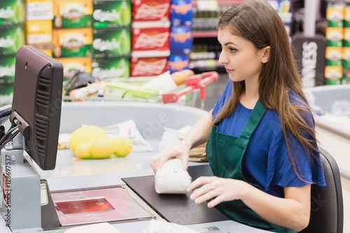 Woman cashier beeping an item