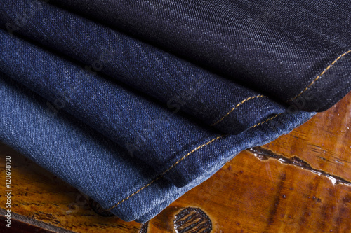 Jeans on a wooden background brown .Frayed Detail of nice