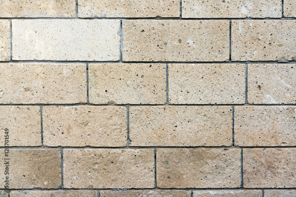 Beige wall lined with stone tile, background, texture Beige wall lined with stone tile, background, texture