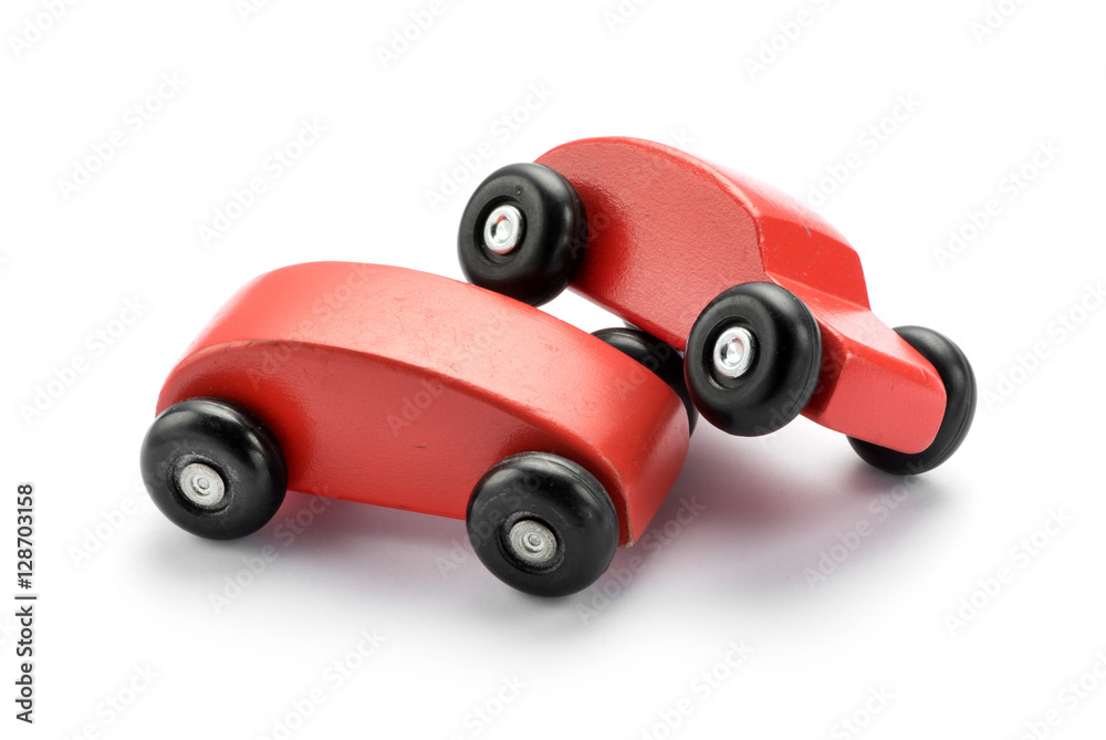 Two wooden toy red cars pile on one another Two wooden toy red cars pile on one another