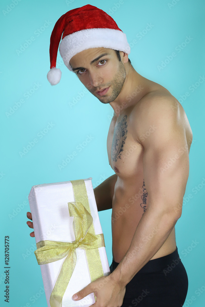 Père Noël sexy tenant un cadeau Stock Photo | Adobe Stock