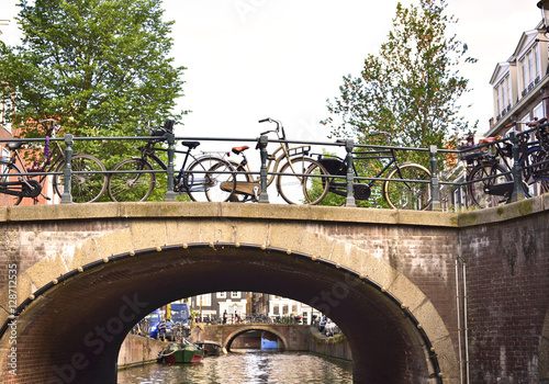 Old bridge at a canal of Amsterdam with bicycles. photo