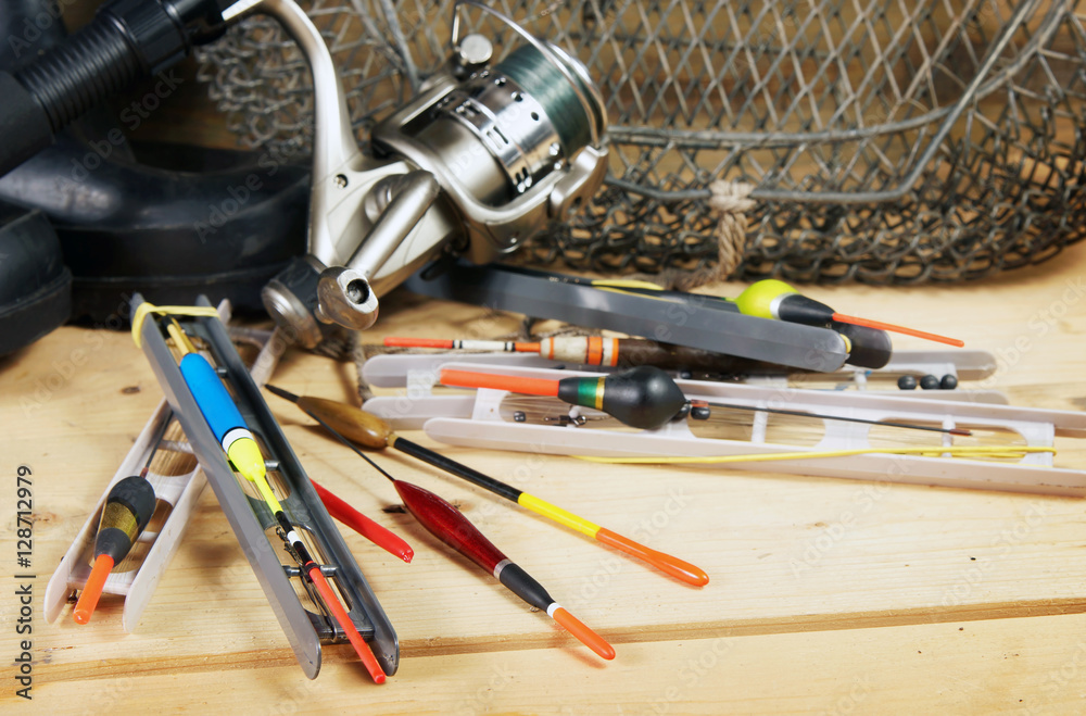 Composition with various fishing floats and other tackles on wooden background