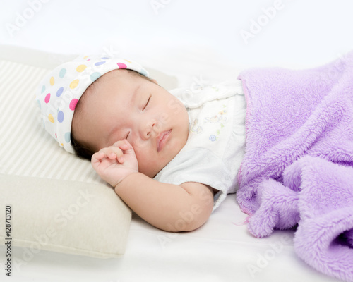 Portrait of adorable baby girl sleeping on the bed with copy spa