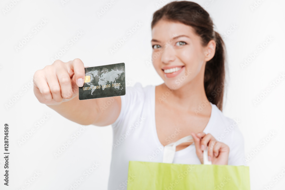 Shopaholic woman holding credit card. Focus on debit. Shopaholic woman holding credit card. Focus on debit.
