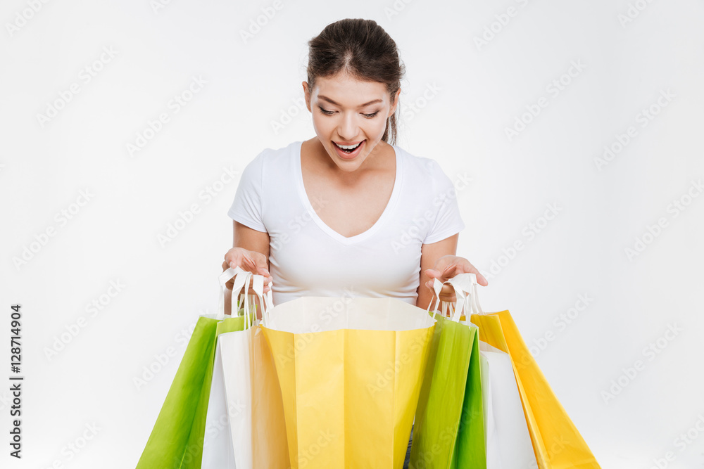 Woman holding purchasings after shopping and looking on them Woman holding purchasings after shopping and looking on them