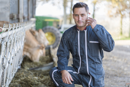 Farmer in barn using phone