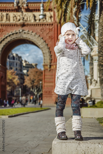 girl near Arc de Triomf in Barcelona, Spain holding her hat © Alliance
