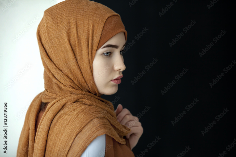 Fototapeta premium Portrait of a beautiful Muslim woman in a green scarf covering her head