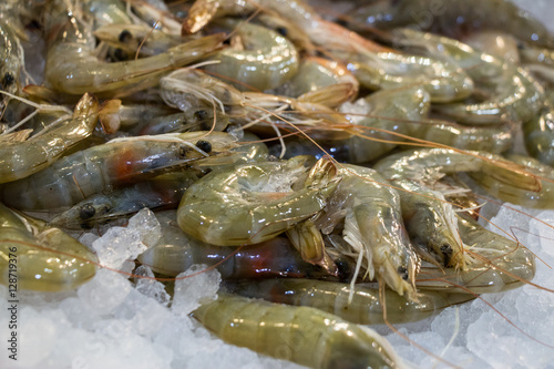 The raw shrimps on ice in fish shop for sale.