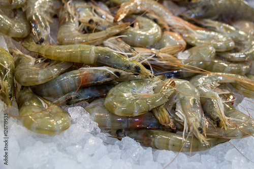 The raw shrimps on ice in fish shop for sale.