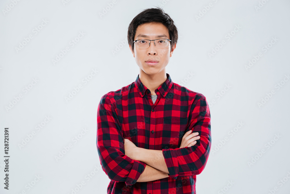 Young man in casual shirt standing with arms crossed Young man in casual shirt standing with arms crossed