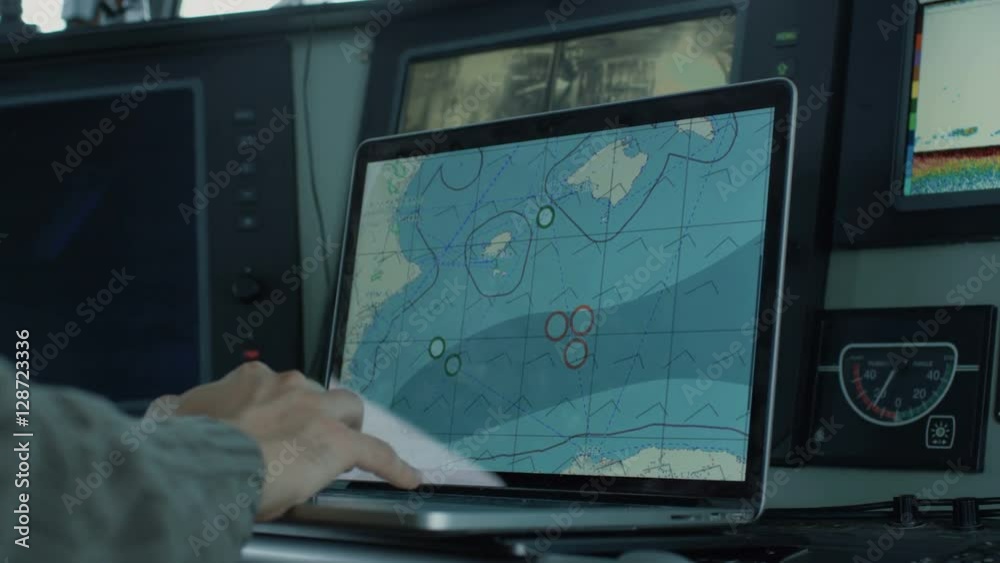 Captain of Commercial Fishing Ship Surrounded by Monitors and Screens Working with Sea Maps in his Cabin.  Shot on RED Cinema Camera in 4K (UHD). 
