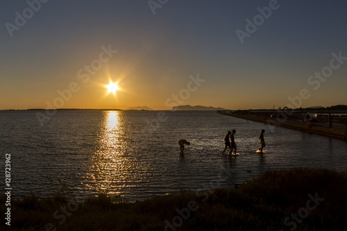 boys swimming at sunset hour