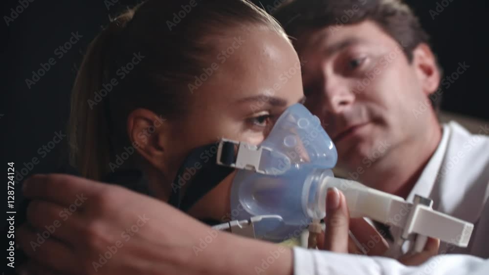Handheld shot of doctor putting oxygen mask on female patient