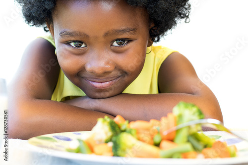 African girl in front of vegetable dish.