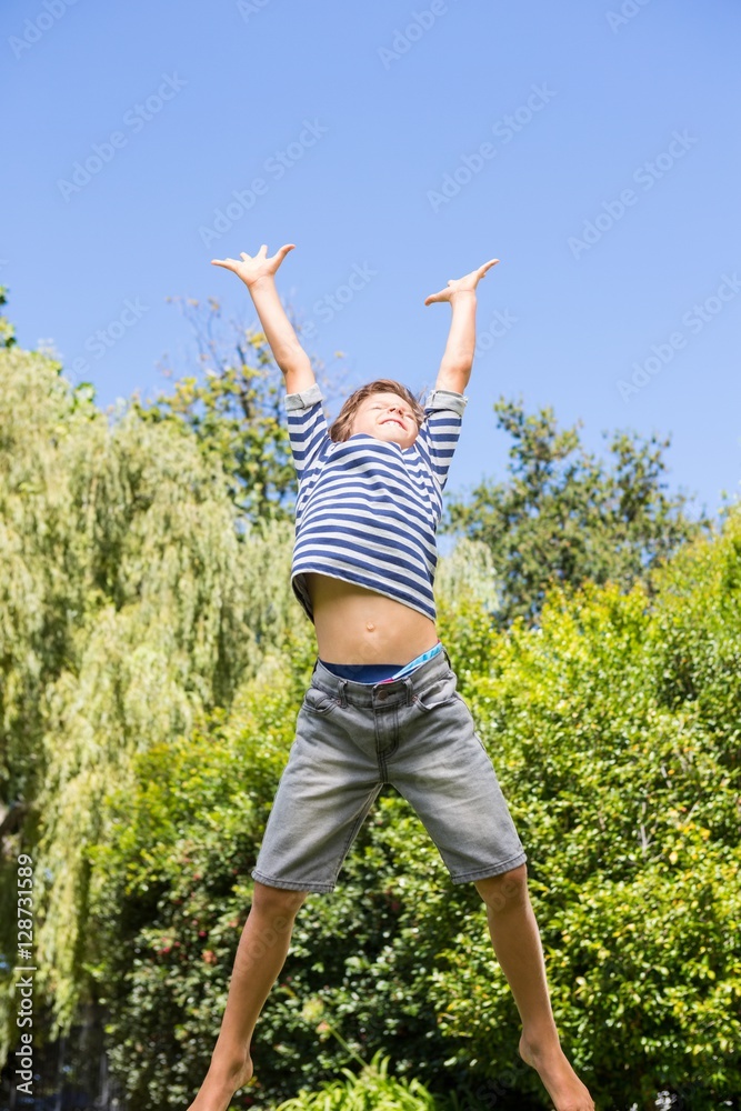 Cute boy jumping with raised arms Cute boy jumping with raised arms