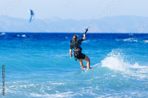 young woman kite-surfer rides in summer day