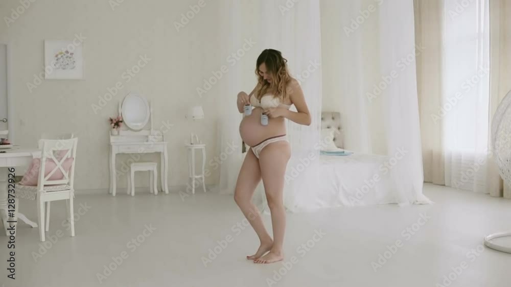 Future mother playing a children's slippers on her belly. Future mother playing a children's slippers on her belly.