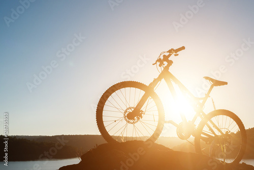 Silhouette Mountain biking on the rock at sky sunset
