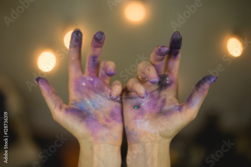 the artist's hand in the paint and sequins space