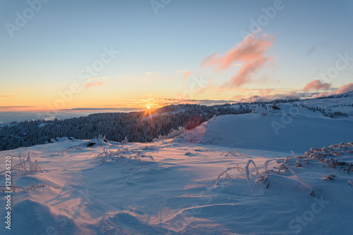 Frosty sunrise at Vitosha mountain, Sofia, Bulgaria - beautiful winter landscape - first rays of sunlight over the fresh snow powder, Black Peak in the background
