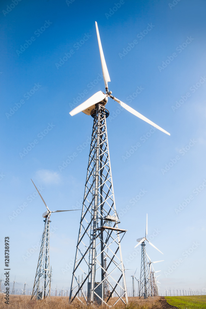View of three wind turbines on blue sky background. Concept of green energy