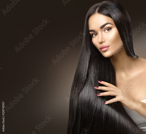 Beautiful long hair. Beauty model girl touching healthy hair photo