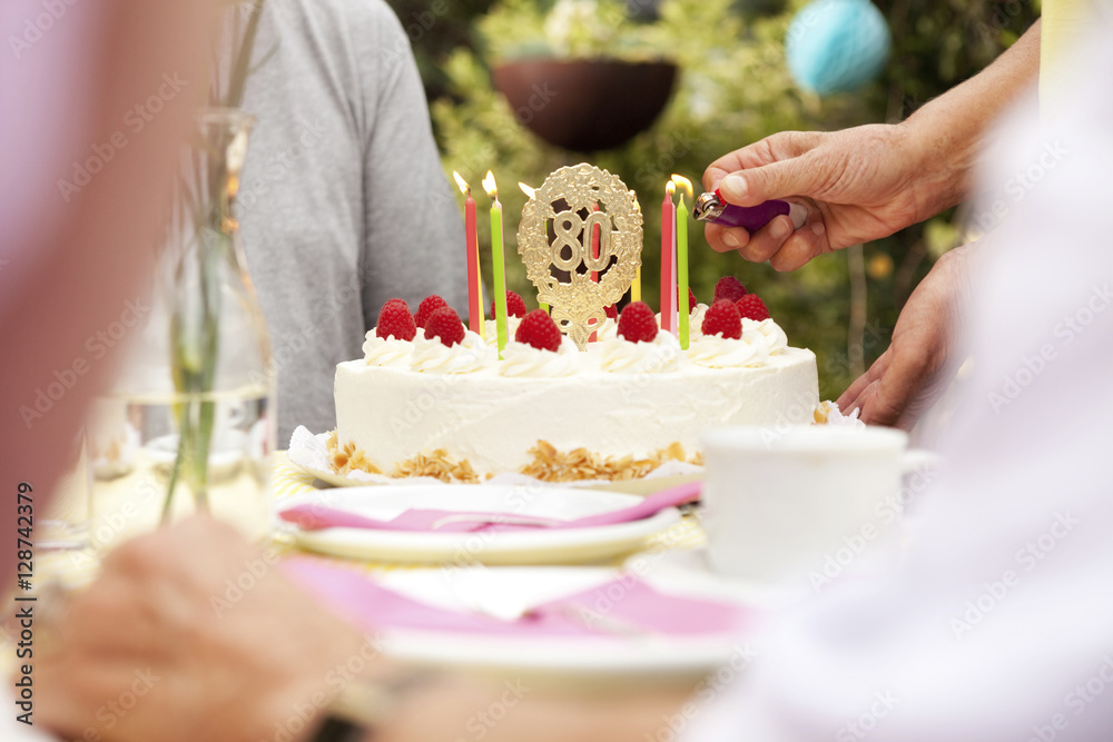 Hand lighting candles on the birthday cake Hand lighting candles on the birthday cake
