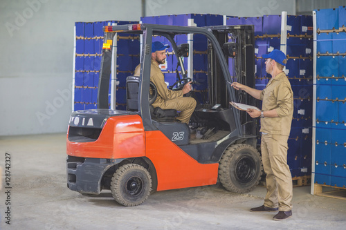 Worker stocking load with forklift