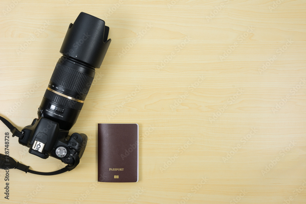 Digital camera and passport on table for travel Digital camera and passport on table for travel