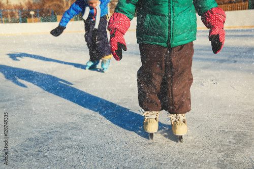 little girl and boy larning to skate, kids winter sport