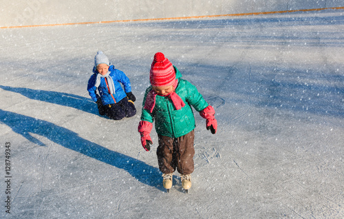 little girl and boy larning to skate, kids winter sport photo