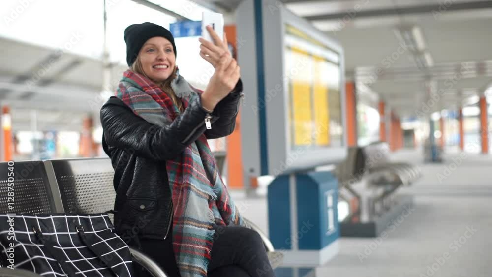 Happy girl having a videocall on smartphone while sitting on a platform
Happy girl having a videocall on smartphone while sitting on a platform