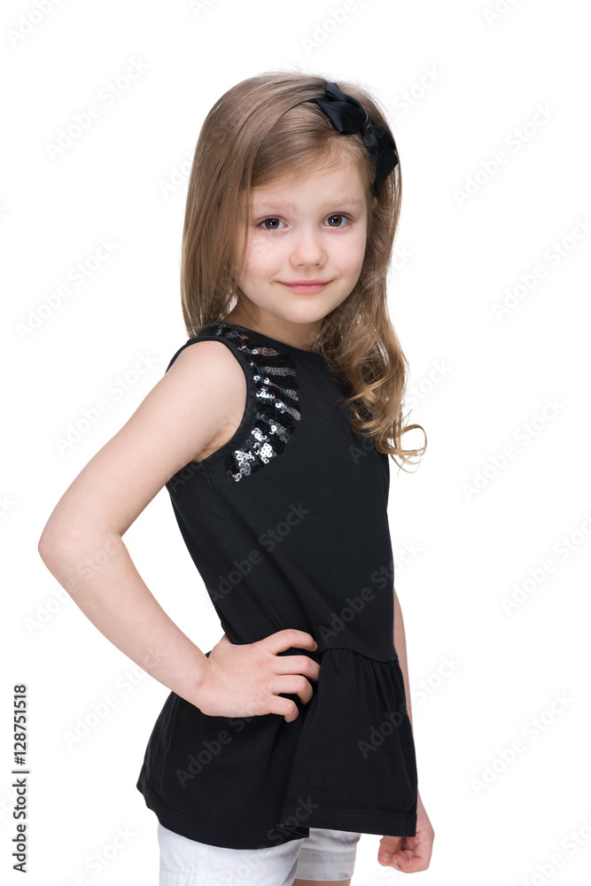 Smiling little girl is standing against the white Smiling little girl is standing against the white