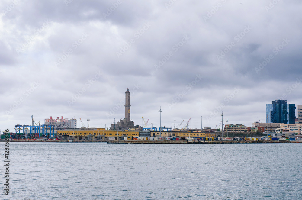 view of the historic lighthouse of Genoa from the industrial harbor of the city, Porto Antico