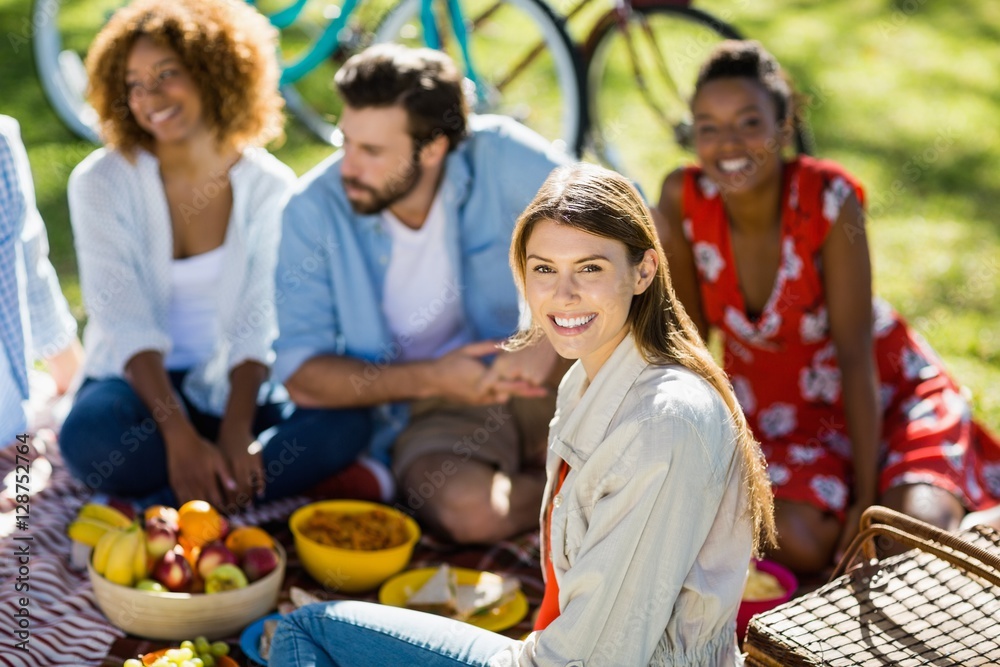 Woman sitting with her friends in park Woman sitting with her friends in park