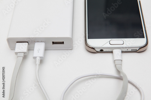 charging smart phone with portable battery on white backgrounds