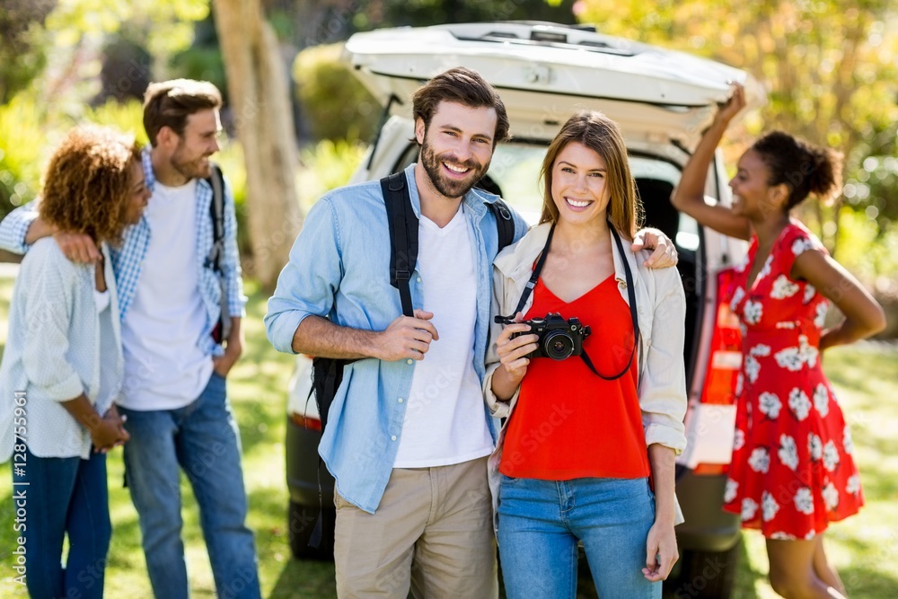 Portrait of couple standing with arm around in park