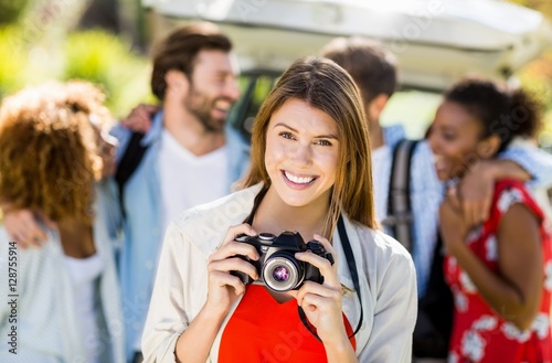 Beautiful woman clicking a photo from camera in park