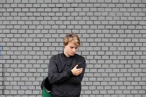 Smiling teenage boy typing text message.Using smart phone. © lado2016