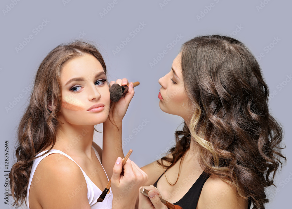 Female friends putting makeup 