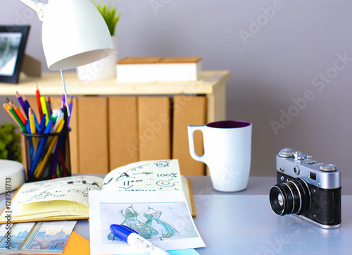 Desk of an artist with lots stationery objects. Studio shot on wooden background